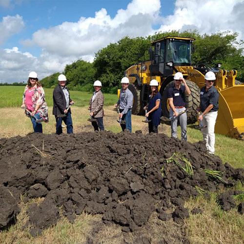 Groundbreaking media event with group putting shovels in dirt