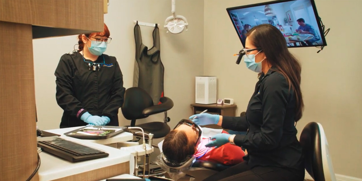 Dentist with patient in dental exam room