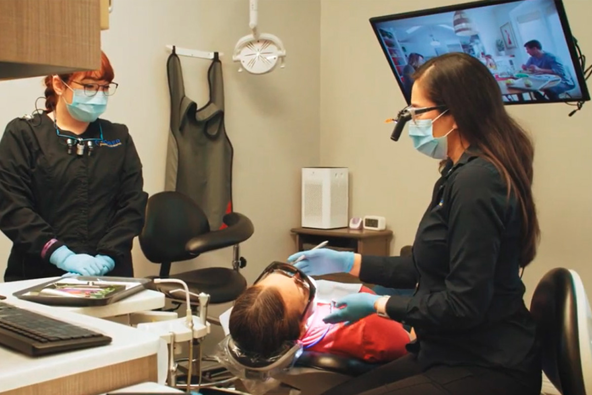 Dentist with patient in dental exam room