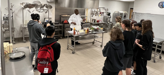 Students learning form chef in a teaching kitchen