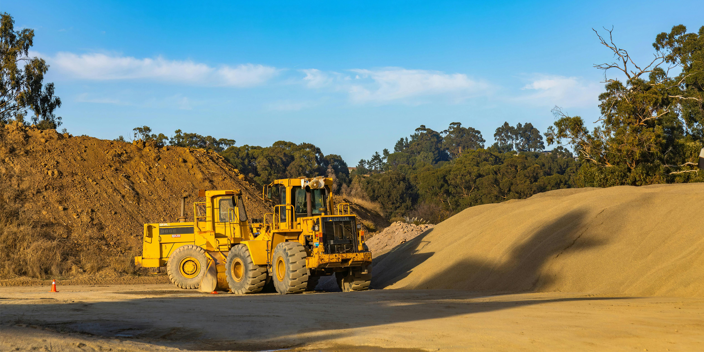 Tractors near dirt mound