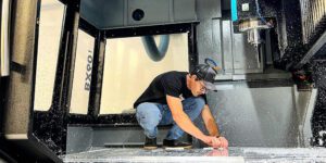 Man working on metal carving machine at Method MFg